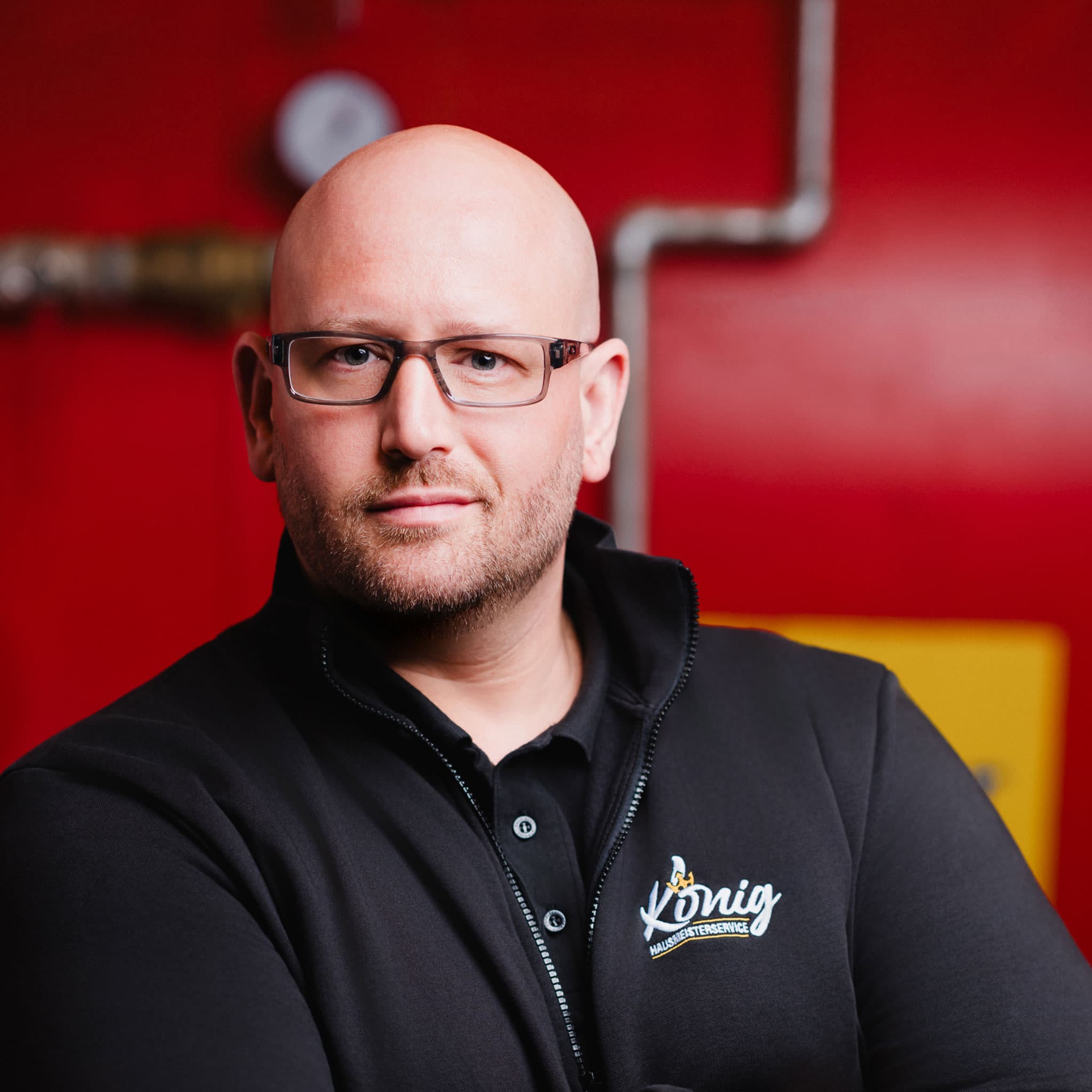 Sven König, Gründer und Geschäftsführer des Hausmeisterservice Sven König in Köln, in professioneller Firmenkleidung.